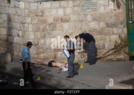 Jerusalem, Israel. 12th October, 2015. Israeli police inspect the body of a Palestinian man who was shot and killed by Israeli police near the Lion Gate in the Old City of Jerusalem, on Oct. 12, 2015. Police shot and killed a Palestinian who allegedly tried to stab them in Jerusalem on Monday, authorities said. According to an initial investigation, a Palestinian man raised the suspicion of police officers at the scene as he walked down the street, police spokesperson Micky Rosenfeld told Xinhua. Credit:  Xinhua/Alamy Live News Stock Photo