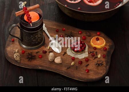 Cranberry citrus punch or mulled wine with ingredients over dark wooden table. Stock Photo