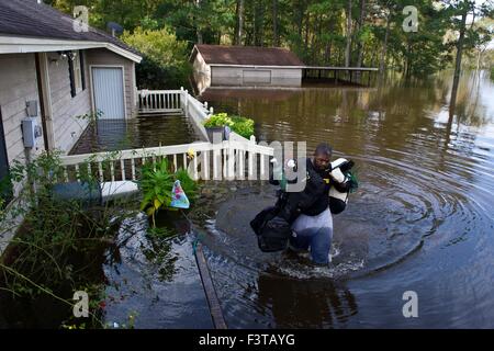 Pittsburgh Steelers football player Clifton Geathers helps remove possessions from his family home overwhelmed by floodwaters October 10, 2015 in Browns Ferry, South Carolina. Large parts of South Carolina suffered from record setting rains that flooded large portions of the state. Stock Photo