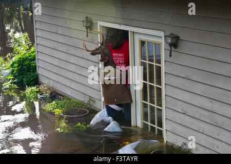 Pittsburgh Steelers football player Clifton Geathers helps remove possessions from his family home overwhelmed by floodwaters October 10, 2015 in Browns Ferry, South Carolina. Large parts of South Carolina suffered from record setting rains that flooded large portions of the state. Stock Photo