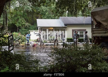 South Carolina National Guard Soldiers unload sandbags to help a resident protect their property from floodwaters October 9, 2015 in Parkers Ferry, South Carolina. Large parts of South Carolina suffered from record setting rains that flooded large portions of the state. Stock Photo