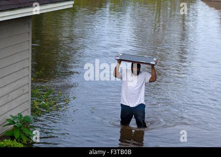 Pittsburgh Steelers football player Clifton Geathers helps remove possessions from his family home overwhelmed by floodwaters October 10, 2015 in Browns Ferry, South Carolina. Large parts of South Carolina suffered from record setting rains that flooded large portions of the state. Stock Photo