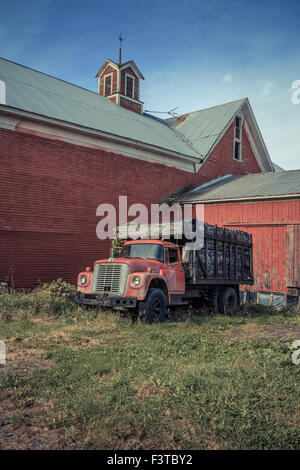 An old red farm truck in front of an old red barn in Vermont. Stock Photo