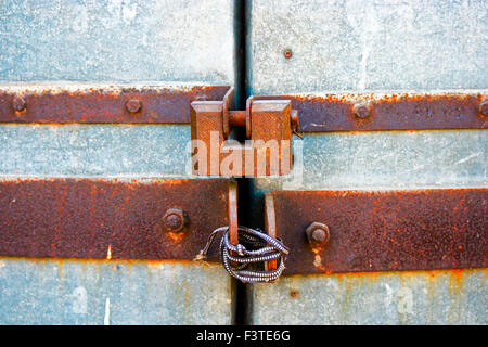 An old rusty lock hanging on the gates, copy space Stock Photo