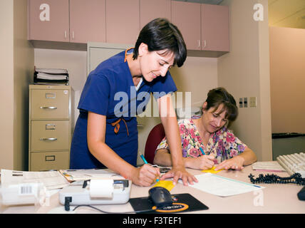 Female Physician and receptionist working together in doctors office. MR © Myrleen Pearson Stock Photo