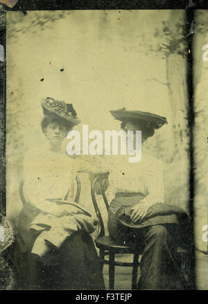 Two women wearing victorian style hats during a photo sitting that produced a tin-type photograph during the late 1800s in the United States of America. Stock Photo