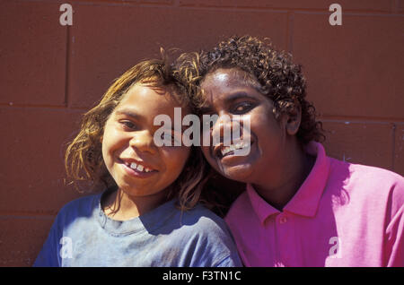 TWO SMILING YOUNG GIRLS FROM THE YUELAMU ABORIGINAL COMMUNITY, NORTHERN TERRITORY, AUSTRALIA. Stock Photo