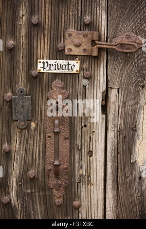 UK, England, Shropshire, Craven Arms, Stokesay Castle, gatehouse, private sign and rusting iron door furniture Stock Photo