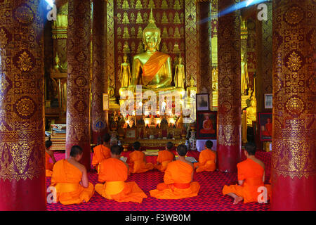 Buddhist monks at worship in Wat Sen temple in  Luang Prabang, Laos Stock Photo