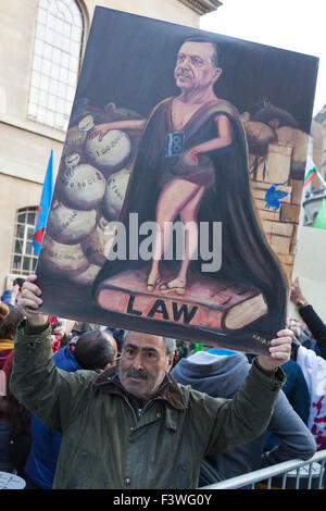London, UK. 11/10/2015. Artist Kaya Mar holds up an oil painting depicting President Erdogan as standing above the law. Several thousand Kurds and Turks marched from Downing Street to the BBC headquarters at Langham Place, to protest against the bombs in Ankara that killed many people attending a peace demonstration. Stock Photo