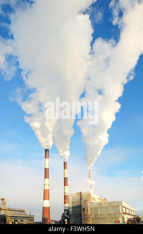 three smoking chimneys of power plant Stock Photo