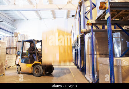 at a warehouse with forklift loader Stock Photo