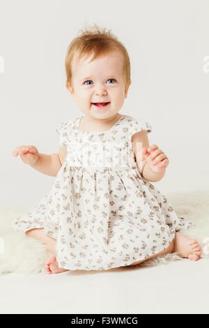 cute little girl smiling sitting on the hide. Stock Photo