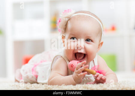Smiling beautiful child girl lies with toy on carpet Stock Photo