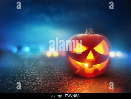 Halloween Night. A Jack O Lantern Pumpkin glowing orange on Halloween evening. Stock Photo