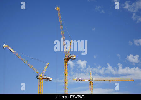 Three yellow tower cranes. Stock Photo