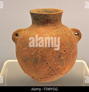 An ancient Chinese handmade red pottery jar with two small ear handles and a deep belly dating to the Neolithic Peiligang Culture circa 6000 to 5200 BC, photographed on a display stand at the Shanghai Museum in Shanghai, China Stock Photo