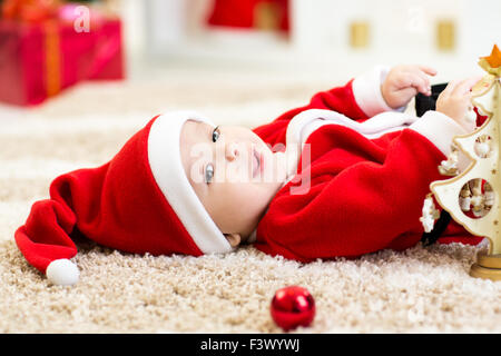 Baby boy weared Santa holding christmas ball Stock Photo