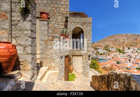 Some local architecture on the hills of the Greek island, Hydra and a view of the sea and houses on the background. Stock Photo