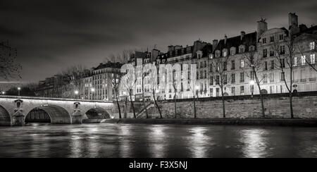 Seine River, Quai de Bourbon on Ile Saint Louis with Pont Marie and evening lights. Row of 19th century buildings, Paris, France Stock Photo