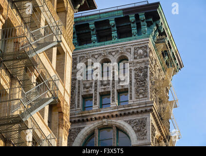 Building facade with terra cotta ornament, copper cornice and fire escapes in Soho, Broome Street, Manhattan, New York City, USA Stock Photo