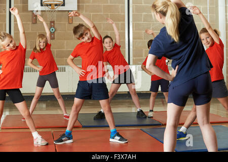 Teacher Taking Exercise Class In School Gym Stock Photo