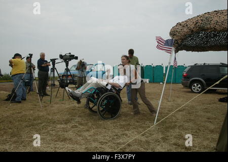 Tomas Young, who was injured on the same day as Casey Sheehan was killed, is pushed past graves representing soldiers killed in the war on terrorism, by his first wife Brie Townsend, during an anti-war protest outside George W Bush's ranch in Crawford, Texas. Stock Photo