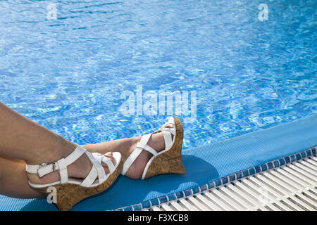 Feet in beach sandal on the brink of pool Stock Photo