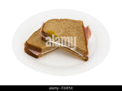 A ham and cheese sandwich that has been cut in half on a white paper plate atop a white background. Stock Photo