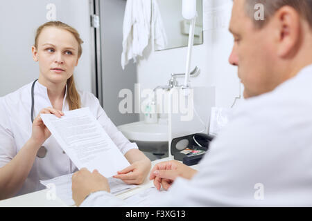 Nurse shows to doctor results of analyses Stock Photo