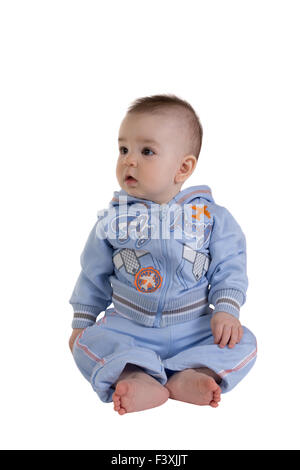 Open-eyed surprised child sitting on the floor Stock Photo