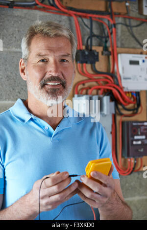 Portrait Of Electrician Standing Next To Fuseboard Stock Photo
