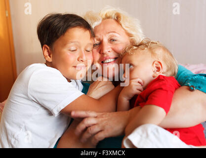 Happy grandmother hugging with her grandsons Stock Photo