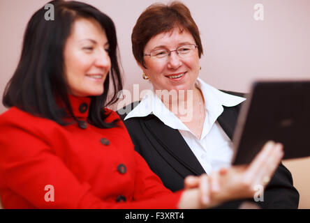 Two women sharing a tablet computer Stock Photo