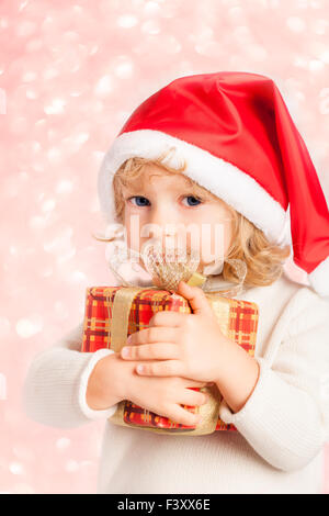 Baby holding Christmas gift in hands Stock Photo