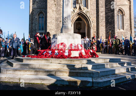 Remembrance Sunday, Ramsgate. Senior ex-serviceman laying a wreath at the cenotaph war memorial outside local church with others standing to attention. Stock Photo