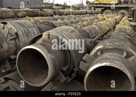 Old metal pipes are cleaned from glass wool Stock Photo