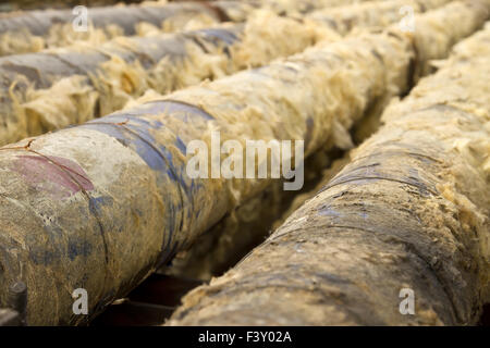 Old metal pipes are cleaned from glass wool Stock Photo