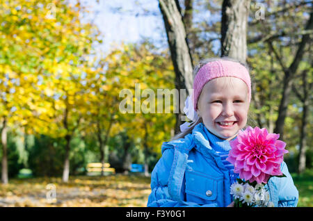 Happy young girl posing with a dahlia Stock Photo