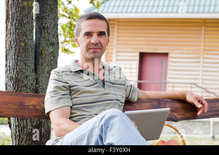Man relaxing on a garden bench Stock Photo