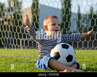 Boy with football shouting with glee Stock Photo