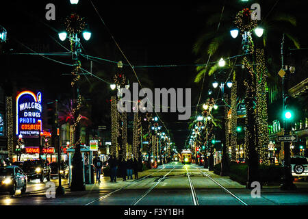 A distant Canal Street car approaches at night amongst festively decorated Holiday lighting scenes in New Orleans, LA Stock Photo