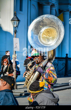 A Street musician plays a tuba in Jackson Square to entertain the tourist in the French Quarter, New Orleans, LA Stock Photo