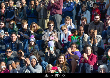 Multitude of diverse people in the USA sitting on bleachers reacting and watching an event Stock Photo