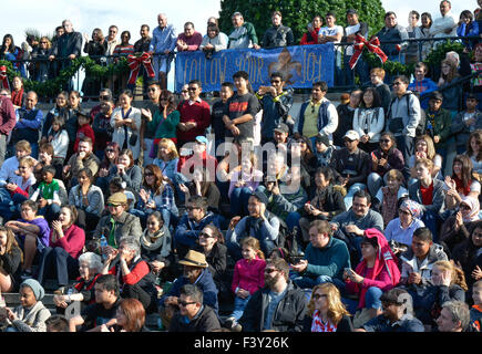 Multitude of diverse people in the USA sitting on bleachers reacting and watching an event Stock Photo