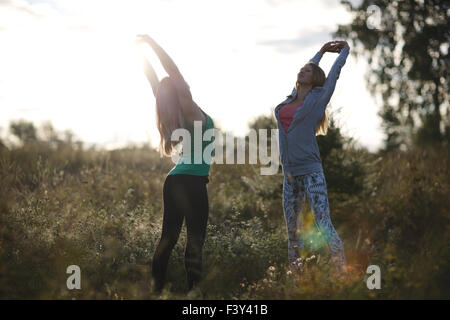 Two young women working out in the garden Stock Photo