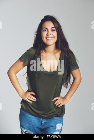 Woman posing for camera. Both hands in side, smiling. Isolated portrait Stock Photo