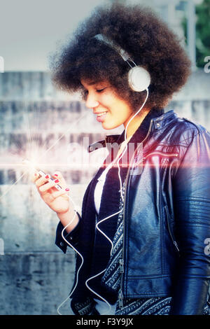 Young, black woman listen music with smartphone Stock Photo