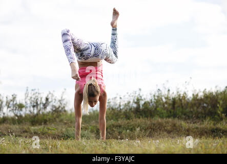 Agile young woman doing a handstand Stock Photo