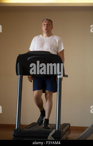 Middle-aged man working out on a treadmill Stock Photo